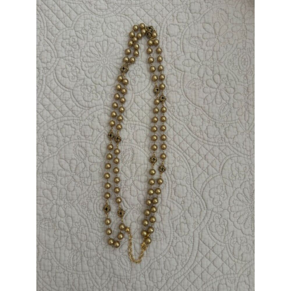 Joan Rivers gold faux pearls and gold love knot long necklace.